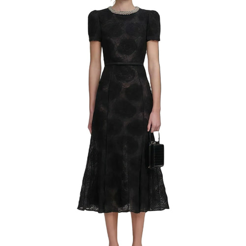 Woman wearing a black patterned dress on a white background